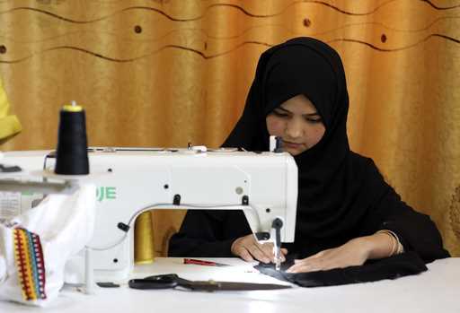 An Afghan woman tailor works with a sewing machine in the Afghan Women Business Hub in Kabul, Afgha…