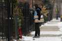 An Amazon delivery man checks his phone for a correct address before he delivers a package during c…