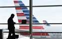 A passenger talks on the phone with American Airlines jets parked behind him at Washington's Ronald…