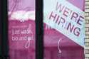 A hiring sign is displayed at a hair salon in Vernon Hills, Ill