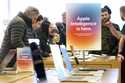 People gather around a table of iPhones at an Apple Store in Pittsburgh on January 8, 2025