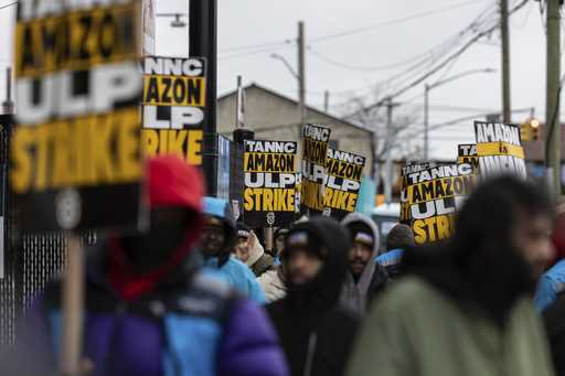 Amazon workers and members of the International Brotherhood of Teamsters picket in front of the Ama…