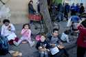 Children eat a free, cooked meal outside a soup kitchen on the outskirts of Buenos Aires, Argentina…