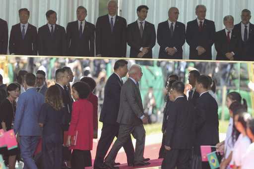 China's President Xi Jinping, left center, and Brazil's President Luiz Inacio Lula da Silva, walk i…