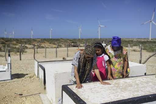 Members of the Indigenous Wayuu community, Zoyla Velasquez, left, and her family, visit the graves …