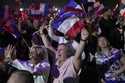 Supporters of French far right leader Marine Le Pen react after the release of projections based on…
