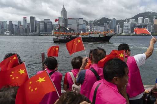 Pro-Beijing supporters hold Chinese flags to mark the 27th anniversary of Hong Kong's return to Chi…