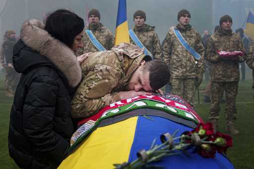 A Ukrainian serviceman bids farewell to his comrade Pavlo Vedybida aka "Obolonchik" at the Obolon S…