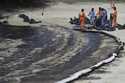 Workers clean oil spill along Sentosa's Tanjong Beach area in Singapore, Sunday, June 16, 2024