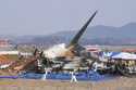 Firefighters and rescue team members work near the wreckage of a passenger plane at Muan Internatio…