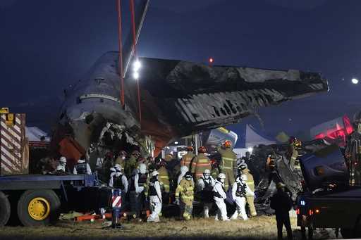 Rescue team carry the body of a passenger at the site of a plane fire at Muan International Airport…