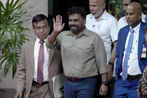 Marxist lawmaker Anura Kumara Dissanayake waves as he departs the election commission office after …