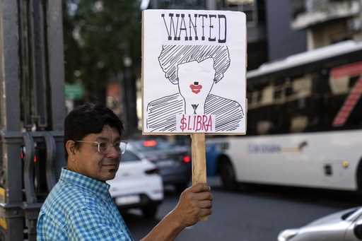 A demonstrator holds a banner depicting President Javier Milei and the $Libra cryptocurrency during…