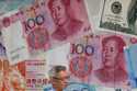 A man walks by a money exchange shop decorated with Chinese yuan banknotes and other countries curr…