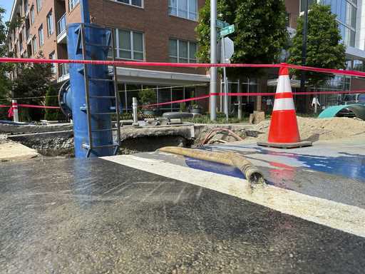 Water trickles out of a hose attached to a device that shuts off flow to a water main on Monday, Ju…