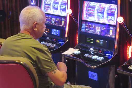 A gambler smokes while playing a slot machine at the Hard Rock casino in Atlantic City, N