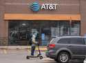 The company logo hangs over the door to a AT&T telephone store, February 22, 2024, in Denver