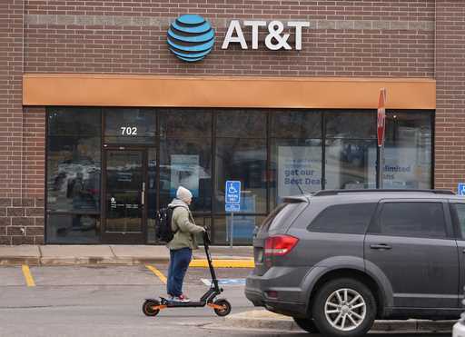 The company logo hangs over the door to a AT&T telephone store, February 22, 2024, in Denver