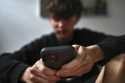 A teenager uses his mobile phone to access social media, Sydney, Wednesday, November 13, 2024