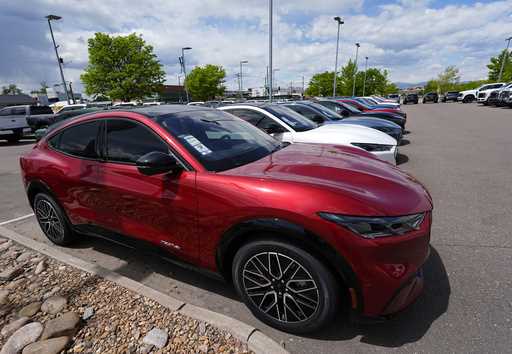 A line of unsold 2024 Mustang Mach-E electric utility vehicles sit at a Ford dealership May 19, 202…