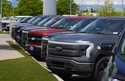 A line of unsold 2024 F150 and Lightning electric pickup trucks sit at a Ford dealership Sunday, Ma…
