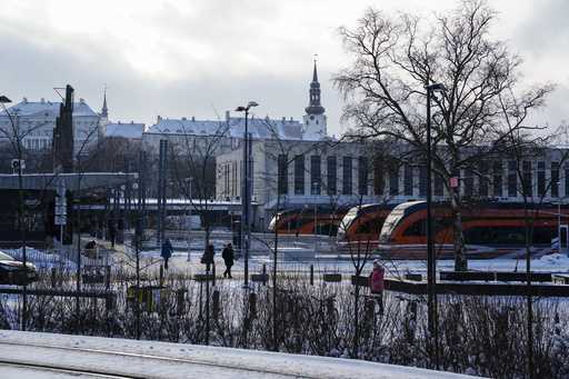 People walk at Baltic train station, with the Stenbock House, left, and St Mary's Cathedral, top, i…