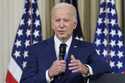 President Joe Biden answers questions from reporters as he speaks in the State Dining Room of the W…