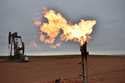 A flare burns natural gas at an oil well in Watford City, N