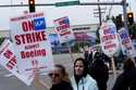 Boeing workers wave picket signs as they strike after union members voted to reject a contract offe…