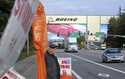 Union machinist Terry Muriekes waves a Halloween-decorated strike sign by Boeing's Everett, Wash