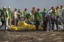 Workers collect debris on March 12, 2019 at the scene where an Ethiopian Airlines Boeing 737 Max 8 …