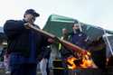 Boeing employee Adrian Camez, who works in Seattle, stokes the fire of a burn barrel as others arri…