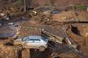 A car and two dogs are on the roof of destroyed houses at the small town of Bento Rodrigues after a…