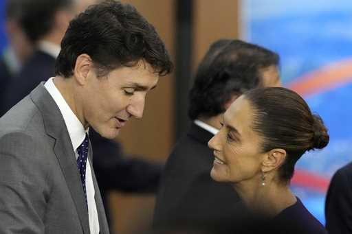 Canada's Prime Minister Justin Trudeau, left, and Mexico's President Claudia Sheinbaum talk during …