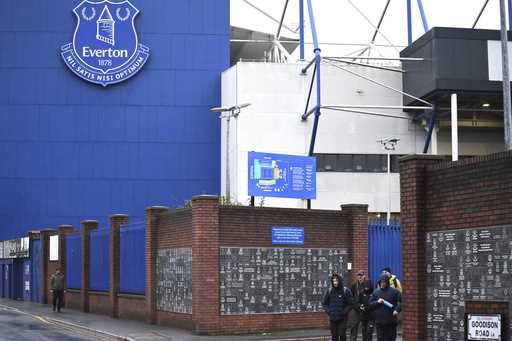 People walk outside Goodison Park as the Premier League soccer match between Everton and Liverpool …