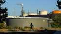 A jogger runs in front of the Phillips 66 refinery, July 16, 2014, in the Wilmington area of Los An…