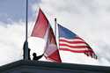 Washington State Park workers put up a new Canadian flag in front of an American flag about to be r…