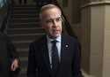 Canada Liberal leader Mark Carney speaks briefly with media as he makes his way to a caucus meeting…