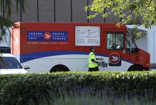 FILE -A Canada Post worker walks to his truck on Sept