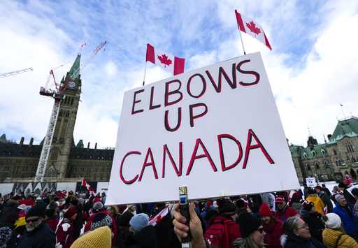 A participant holds an "Elbows Up Canada" sign during rally in response to U