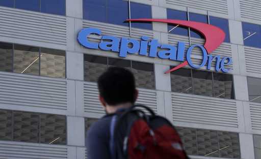 A man walks across the street from a Capital One location in San Francisco