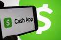 Cash App logos are seen on a phone screen, Sept