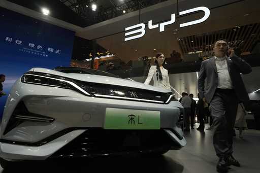 A model poses near the BYD Song L EV car during Auto China 2024 held in Beijing, April 25, 2024