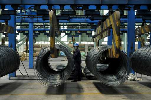 A worker transfers steel cables at a steel factory in Qingdao in east China's Shandong province, on…