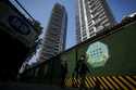 Workers install billboards outside a mall in Beijing, Friday, October 18, 2024