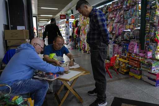 A foreign buyer bargains toys prices with a vendor at the Yiwu wholesale market in Yiwu, east China…