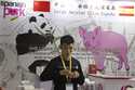 A promoter at a booth for imported Spanish pork prepares for another day at the China International…