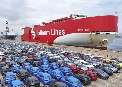 New cars wait for transportation near a Sallaum Lines ro-ro ship seen by the dock in Yantai in east…