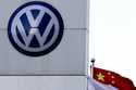 A Chinese national flag flutters near a Volkswagen logo in Beijing, Tuesday, April 18, 2017