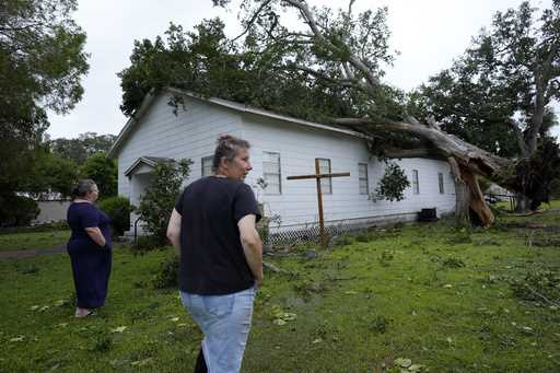 Ann McCauley, right, examines the damage at Bethel Church after Hurricane Beryl moved through the a…